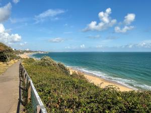 een strand met een hek naast de oceaan bij Sandbourne in Bournemouth