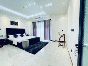 a bedroom with a king sized bed and a chair at Gimhani Villa Hiriketiya in Dickwella