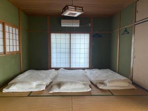 a large bed in a room with two large windows at 柿畑の宿 Private stay with farm and house all to yourself in Katsuragi
