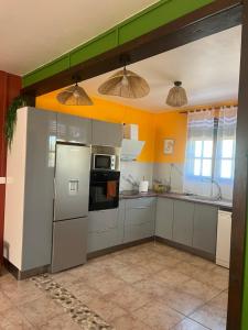 a kitchen with a refrigerator and a microwave at Vi la dous Kreyol in Sainte-Rose