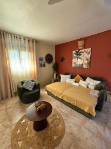 een slaapkamer met een bed, een bank en een tafel bij Vi la dous Kreyol in Sainte-Rose