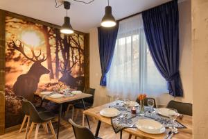 a dining room with two tables and a painting of deer at Chata u Bożeny in Muszyna