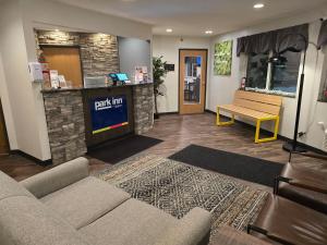 a living room with a couch and a bar at Park Inn by Radisson Ortonville in Ortonville