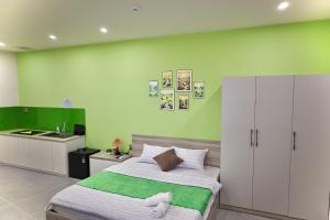 a bedroom with a bed and a green wall at Minimalhaven Stay in Vung Tau