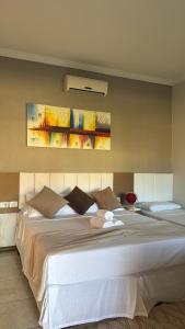 a bedroom with a large white bed in a room at Pousada Vista da Pedra in Itamaraju +93 photos
