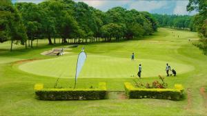 a group of people playing golf on a golf course at Sunset Statehouse View Residence A in Entebbe