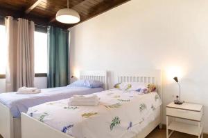 een slaapkamer met een wit bed met handdoeken erop bij Casa Los Lagos 1CD El Cotillo in Cotillo