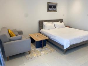 阿克拉Executive Studio at Bantree的一间卧室，里面有一张床、一张沙发和一张桌子 更多14张照片