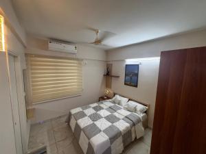 a small bedroom with a bed and a window at Zenith apartement in Trivandrum