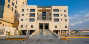 a white building with a ramp in front of it at Karim Hotel in Dammam