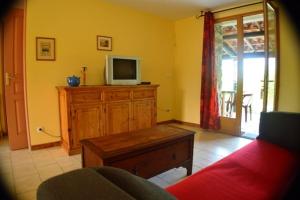 a living room with a tv on a wooden dresser at Mirabel #3, Maisonette, terrace and pool access in Grospierres