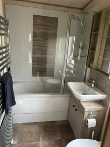 a bathroom with a tub and a sink and a shower at Bude 20 in Newquay +8 photos