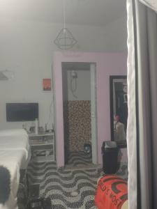 a bedroom with a bed and a room with a mirror at Espaço em Pero hospedagem in Cabo Frio