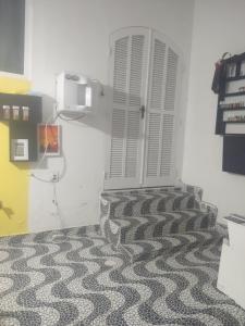 a room with a white door and a carpet at Espaço em Pero hospedagem in Cabo Frio