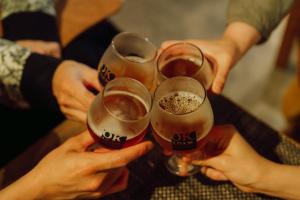 a group of people holding up glasses of beer at Hostel&Bar CAMOSIBA in Yokote