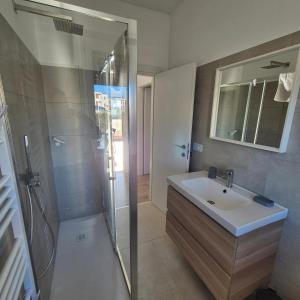 un bagno con lavandino e doccia di Appartamento Scossicci a Porto Recanati