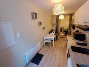 a small kitchen and living room with a table at Le studio des quais in Bergerac