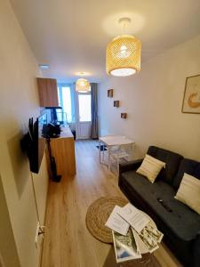 a living room with a couch and a table at Le studio des quais in Bergerac