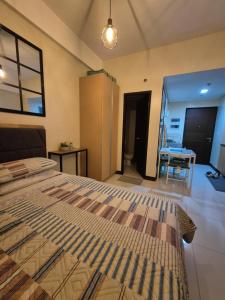 a bedroom with a bed and a table in a room at Jacob's Place Near Manila Airport in Manila