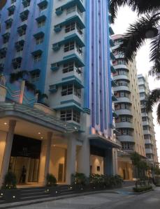 a large apartment building with palm trees in front of it at Jacob's Place Near Manila Airport in Manila +5 photos