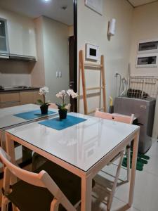 a kitchen with a white table and chairs with flowers on it at Jacob's Place Near Manila Airport in Manila
