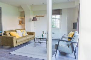 een woonkamer met een bank en een tafel bij Landelijk appartement Friesland in Harich