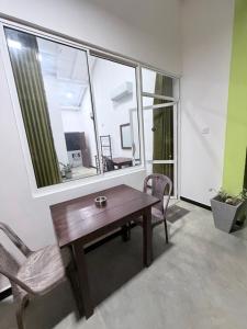 a table and chairs in a room with a large window at Jungle Restaurant and Villa in Unawatuna