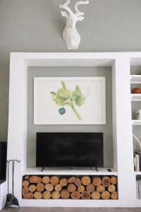 een open haard in een woonkamer met houtblokken bij Skuurtjie in Prince Albert +8 foto's