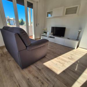 un soggiorno con un divano e una televisione di Appartamento Scossicci a Porto Recanati Altre 27 foto