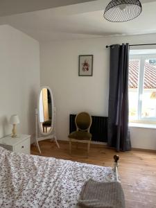 a bedroom with a bed and a mirror and a chair at Gite St Vincent in Foix