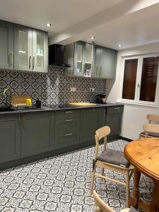 a kitchen with green cabinets and a wooden table at Gite St Vincent in Foix