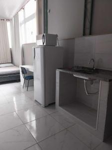 a kitchen with a refrigerator and a counter with a sink at KITNET ELVIS PRESLEY - Largo do Machado in Rio de Janeiro