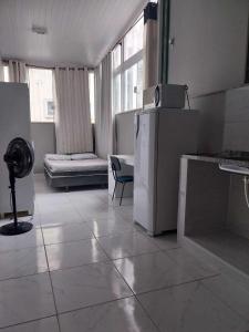 a kitchen with a refrigerator and a couch in a room at KITNET ELVIS PRESLEY - Largo do Machado in Rio de Janeiro