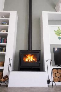 een open haard in een woonkamer met een open haard bij Skuurtjie in Prince Albert