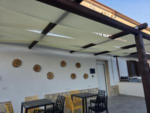 een kamer met tafels en stoelen en een plafond met balken bij B e B LEMI in Ponte