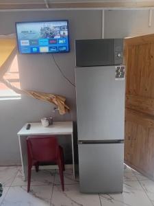 een keuken met een koelkast en een tafel en een televisie bij Tk guesthouse in Sasolburg +4 foto's