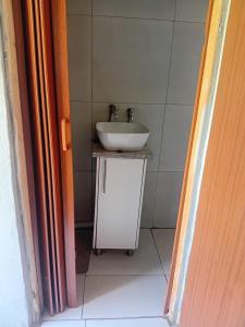 een badkamer met een witte wastafel en een witte tegelmuur bij Tk guesthouse in Sasolburg