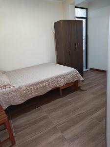 una camera da letto con un letto e un armadio in legno di Habitaciones en la Casa de Dora, 4to y 5to piso ad Ayacucho
