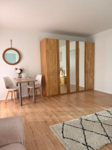 a living room with a table and a mirror at Waldblick Gästezimmer in Sonnenbühl