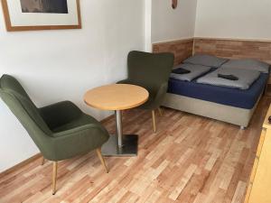 a small room with a bed and two chairs and a table at Malý apartmán na Šumavě in Horní Vltavice