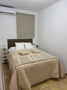 a bedroom with a large bed with two pillows on it at Velazquez in Lora del Río