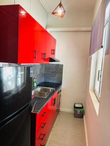 a kitchen with red cabinets and a sink at Μateo suite in Levádeia