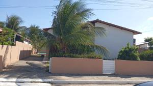 a palm tree in front of a house at Pousada da Sol na Praia do Frances in Praia do Frances