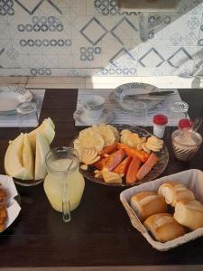 a table with plates of food and bread and cheese at Pousada da Sol na Praia do Frances in Praia do Frances