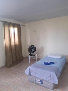 een slaapkamer met een bed en een stoel erin bij Quintal Hospedagem in Soure