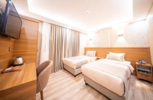 a hotel room with two beds and a television at Zirvesta Otel in Istanbul