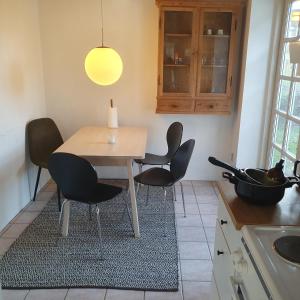 a kitchen with a table and chairs in a kitchen at Slotsgaardens ferielejlighed in Rødding +4 photos