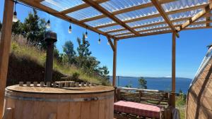 un tonneau en bois avec une table et des chaises sous une pergola dans l'établissement Domo Buena Vista, 