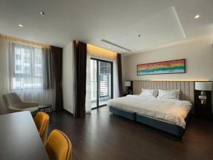 een hotelkamer met een bed, een tafel en stoelen bij Sapphire Residence Hạ Long in Ha Long