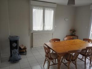a dining room with a wooden table and chairs at La Petite Maison Celtique in Saint-Nicolas-du-Pélem